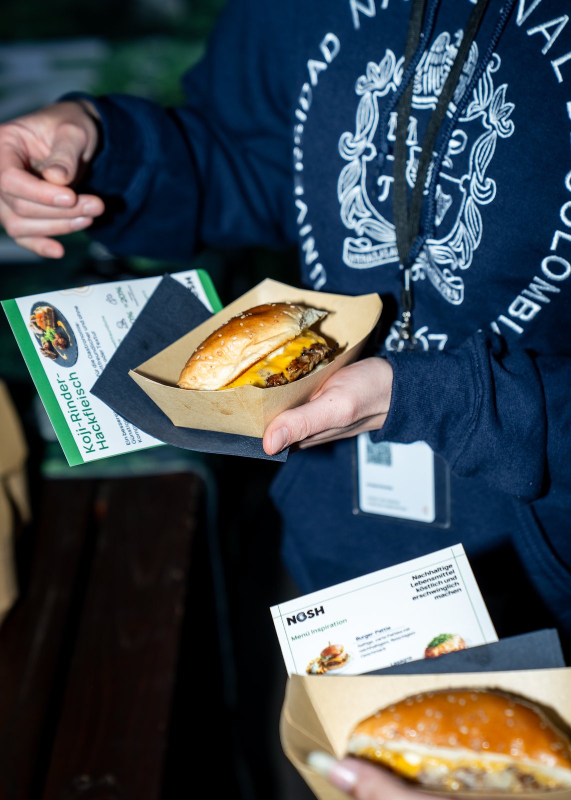 Fertiger Nosh Burger mit Koji-Rinder-Hackfleisch in der Hand einer Besucherin auf der Food Connect Expo