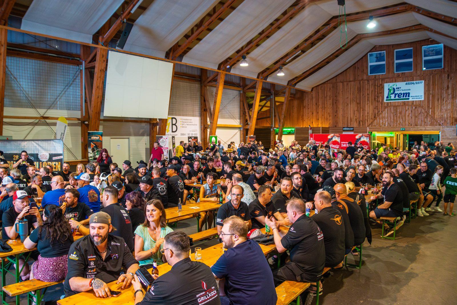 Grillteams sitzen spätabends gemeinsam an den Tischen der Österreichischen Grillmeisterschaft 2026
